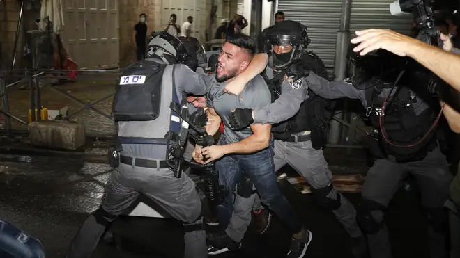 Israeli police wrestle a Palestinian man