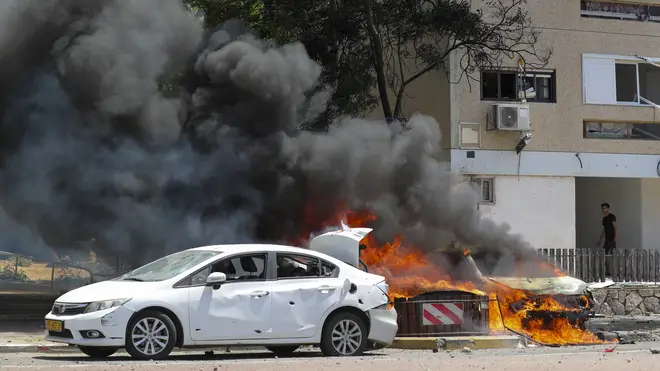 Cars burn after being hit by a missile fired from the Gaza Strip in the southern Israeli town of Ashkelon