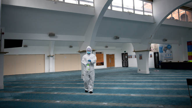 A staff member at Green Lane Mosque in Birmingham disinfects prayer rooms, ahead of Eid al-Fitr