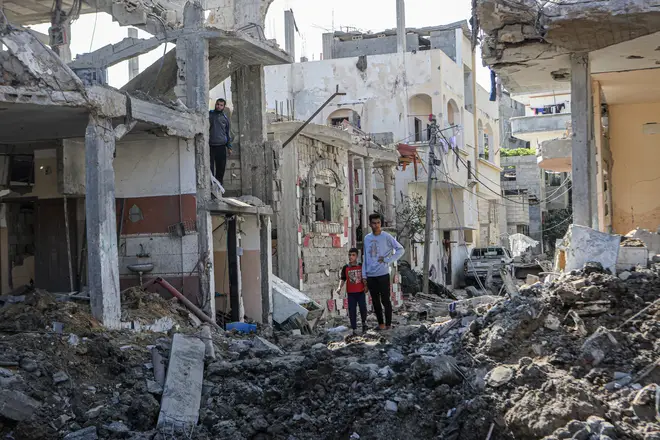 Palestinians inspect damage to a neighbourhood