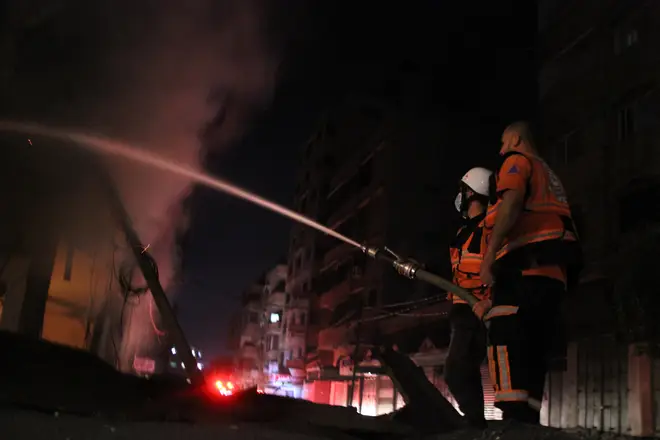 Firefighters attempt to extinguish flames after a Israeli airstrike in Gaza City.