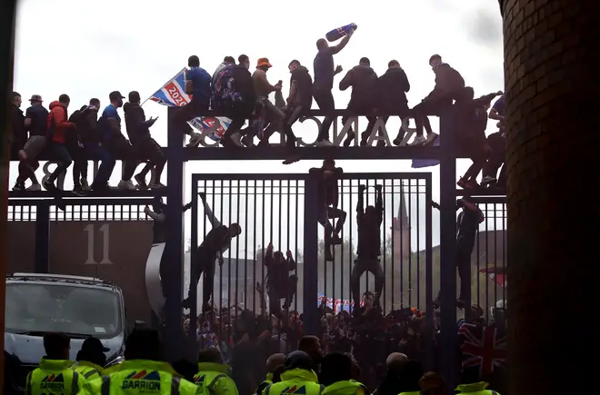 Rangers fans sit on the gate outside the ground during the Scottish Premiership match at Ibrox Stadium.
