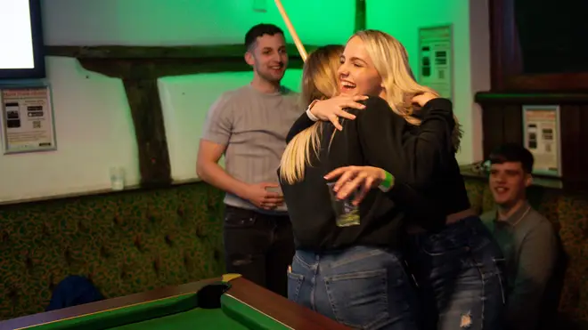 Friends hug for the first time in months inside the Oak Inn in Coventry