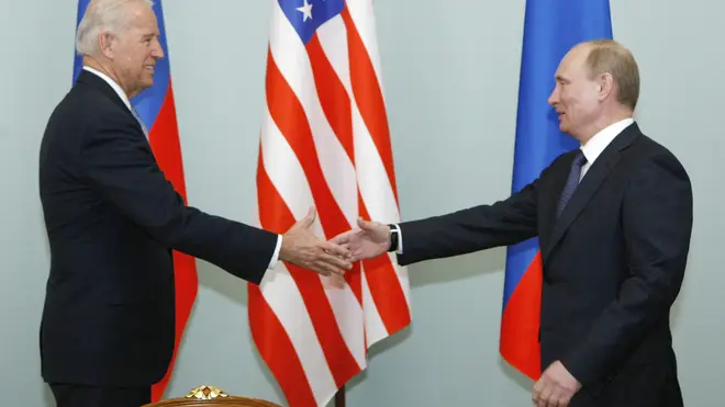 Joe Biden shakes hands with Vladimir Putin