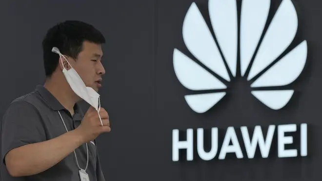 A worker waits for customers inside a Huawei store in Beijing