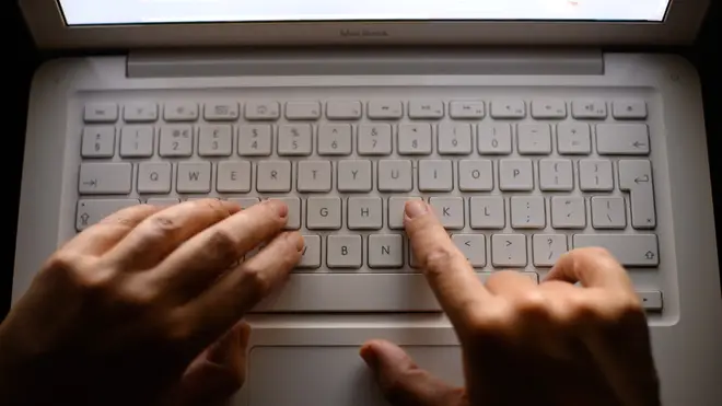 Hands over laptop keyboard