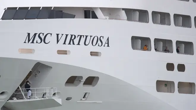 Passengers look out from the side of the cruise ship MSC Virtuosa as it departs Southampton