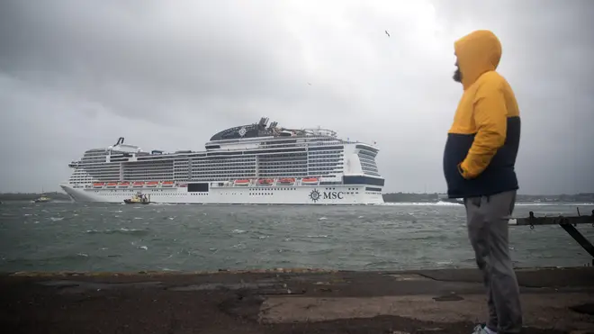 A person looks out to sea as the cruise ship MSC Virtuosa departs Southampton