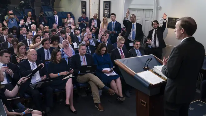 Journalists raise their hands to ask a question in the White House (Evan Vucci/AP)