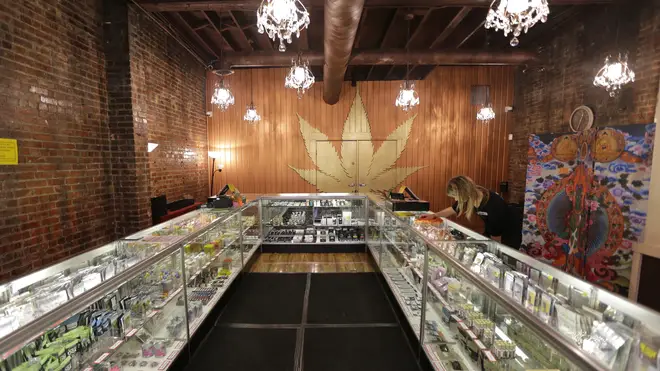 A worker cleans a display case at the Ganja Goddess Cannabis Store in Seattle