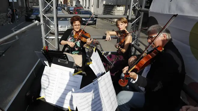 Members of the Budapest Festival Orchestra play music on the back of a truck