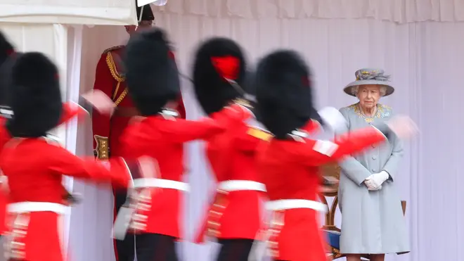 The Queen looks on as Guardsmen perform a mini Trooping the Colour