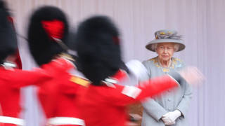 The Queen looks on as Guardsmen perform a mini Trooping the Colour