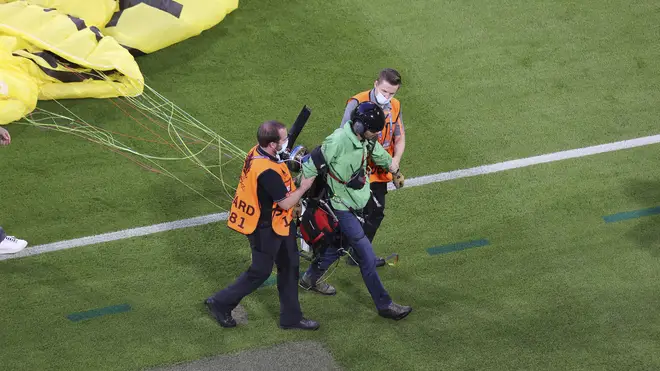 The Greenpeace activist was escorted off the pitch after receiving medical assistance.