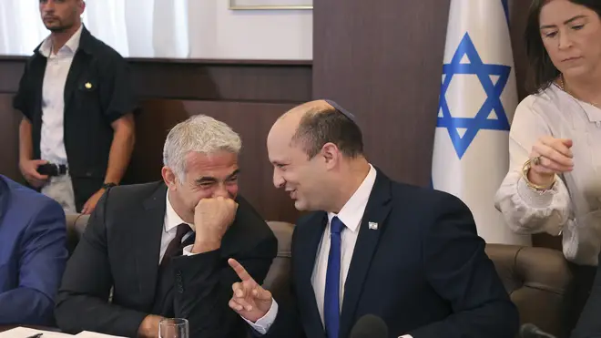 Israeli prime minister Naftali Bennett, right, shares a joke with alternate prime minister and foreign minister Yair Lapid (Emmanuel Dunand/AP)