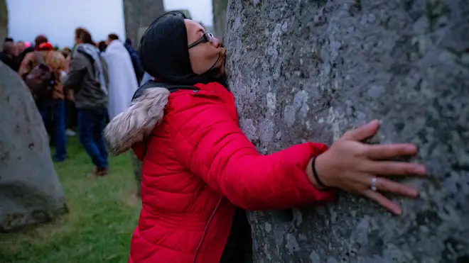 A woman kisses a stone