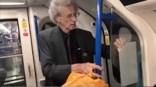 The footage shows Piers Corbyn removing the stickers and putting them into an orange carrier bag