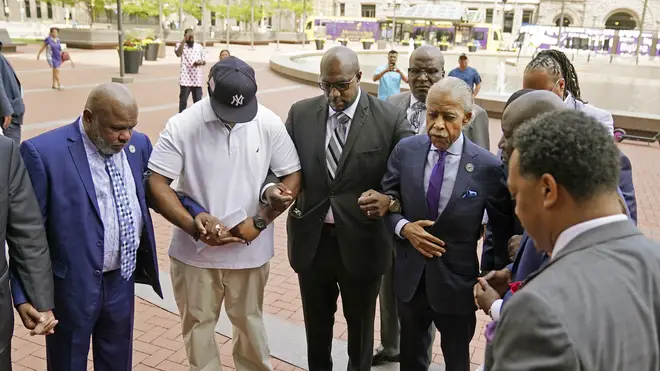 The Rev. Al Sharpton, right, with hand on coat, along with family members of George Floyd leads a prayer before entering the Hennepin County Government Center for the sentencing of former Minneapolis police officer Derek Chauvin,