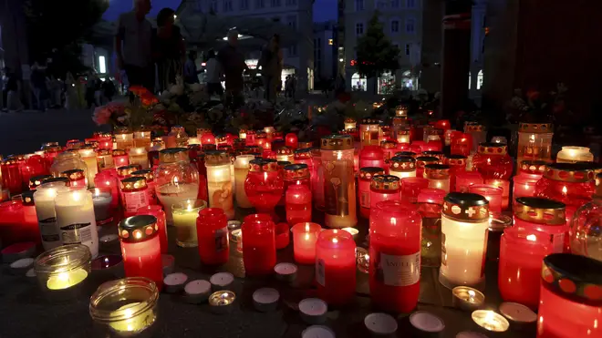 Flowers and candles in front of a closed and cordoned off department store in the city centre of Wuerzburg, Germany (Karl-Josef Hildenbrand/AP)