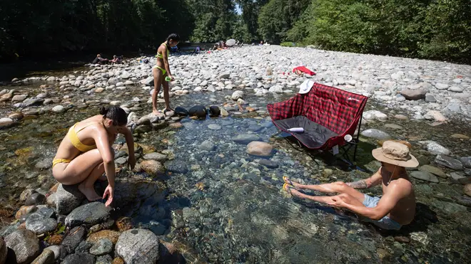 People cool off in the frigid water of Lynn Creek in North Vancouver