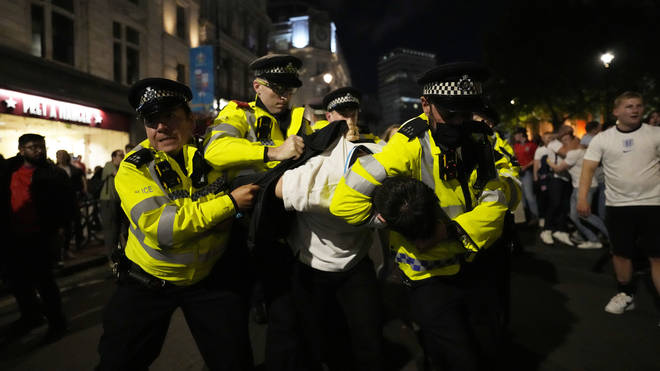 Police detain a man near Trafalgar Square during celebrations after England won against Denmark.