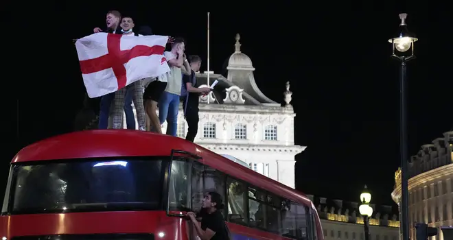 Fans celebrate on top of a bus in central London.