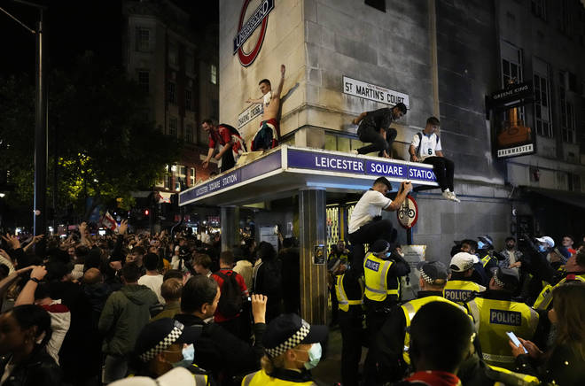 England fans stand on the roof of Leicester Square underground station in central London.
