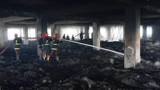 Firefighters at the site of the blaze where 52 died