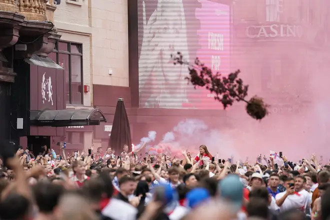 Partying England fans throw a tree in Leicester Square, central London.