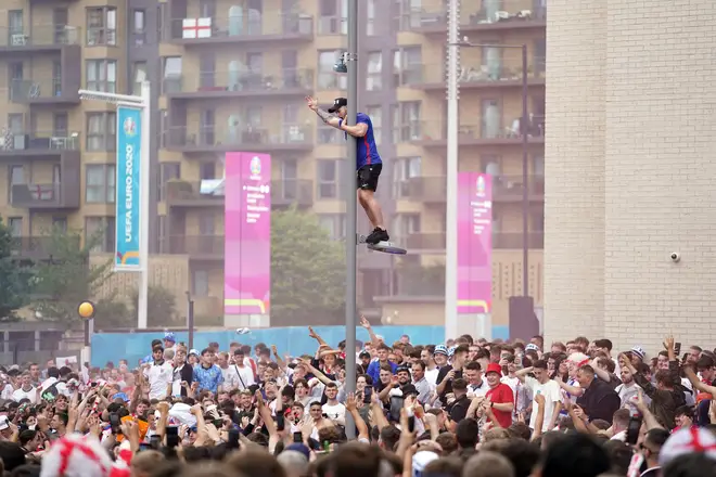 One fan climbs a lamppost outside Wembley