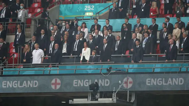 George, William and Kate stand for the national anthem