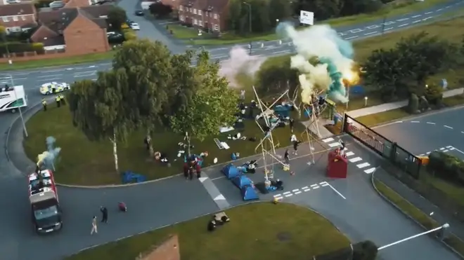 Protesters set up tents and scaled two structures at the gates, setting off flares