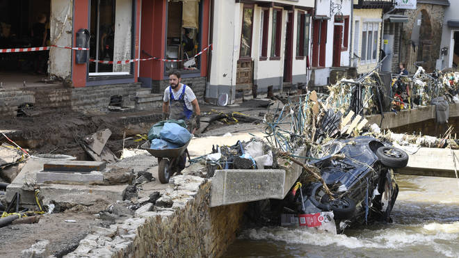 A man helps with the cleanup by carrying rubbish and debris after heavy rain and flooding along the Erft in Bad Münstereifel, Germany