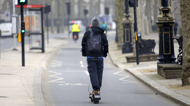 File photo of a man riding an e-scooter along London's Victoria Embankment