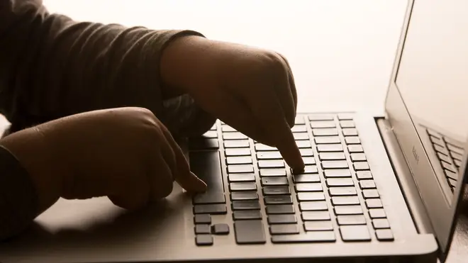 A child’s hands on the keys of a laptop keyboard