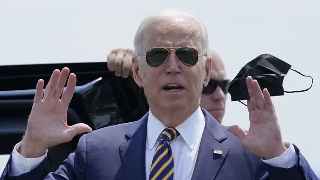 President Joe Biden holds a mask as he responds to a question as he arrives at Lehigh Valley International Airport