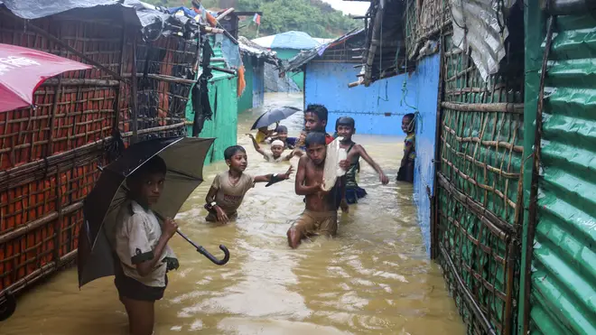 Children play in floodwaters at a Rohingya refugee camp