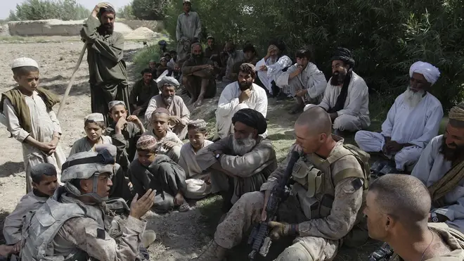 A translator for US Marines speaks with Afghan villagers in Helmand province