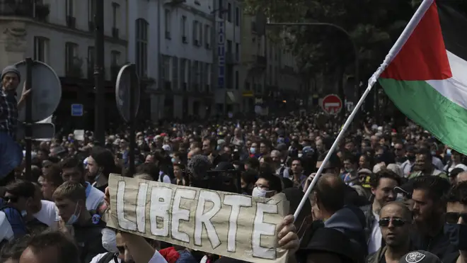 Protesters hold up a banner which reads 'freedom' in French during a demonstration in Paris (Adrienne Surprenant/AP)