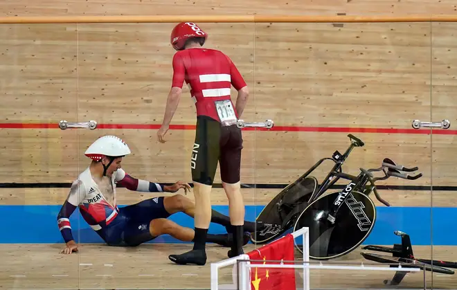Great Britain's Charlie Tanfield picks up his bike after being crashed into by Denmark’s Frederik Madsen in the men’s team pursuit