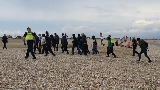 A group of migrants pictured yesterday landing near Dungeness power station