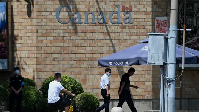 People walk past the Canadian Embassy in Beijing on Tuesday