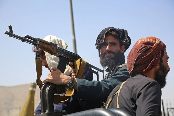 Taliban fighters stand guard in a vehicle along the roadside in Kabul on August 16, 2021