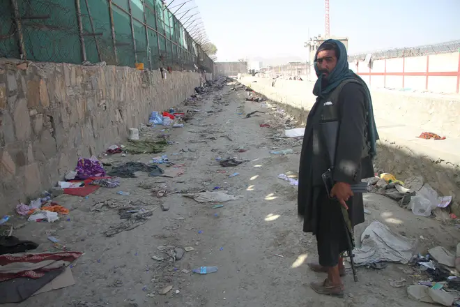 A Taliban member stands near the site of the attack at Kabul airport