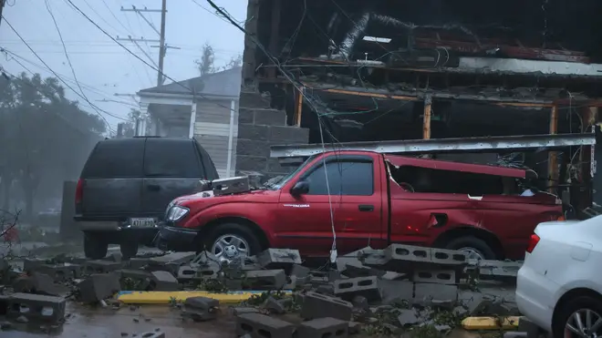 Vehicles are damaged after the front of a building collapsed in New Orleans during Hurricane Ida