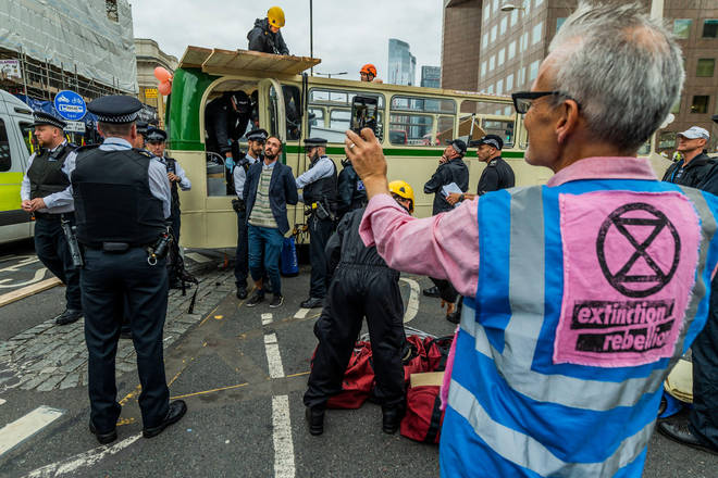 Police officers broke the windows of the bus while protesters attempted to stop them boarding