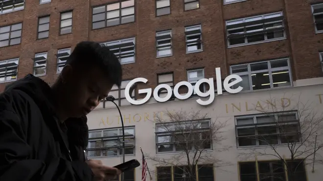 A person walks past a Google sign