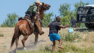 United States Border Patrol agent on horseback attempting to try and stop a Haitian migrant from entering an encampment on the banks of the Rio Grande near the Acuna Del Rio International Bridge in Del Rio, Texas