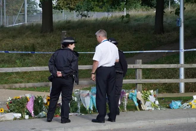 Police officers by floral tributes at Cator Park in Kidbrooke