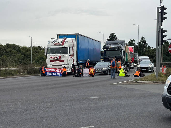 Furious drivers beeped their horns as just nine protesters brought the road to a standstill, gluing their hands to the floor.